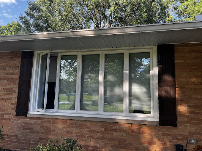 A brick house with white windows and black shutters