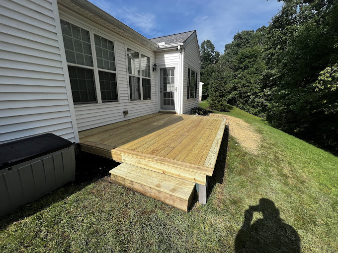 A wooden deck in front of a white house